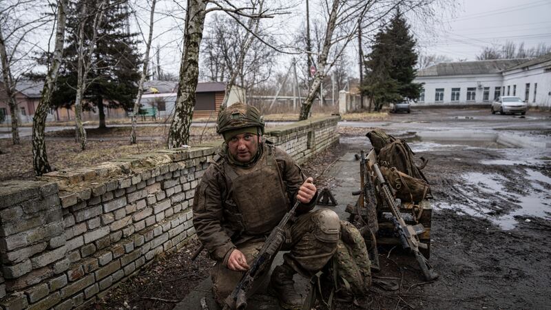 A Ukrainian serviceman, Mykhailo, cleans his gun from mud as he comes back from the trenches...