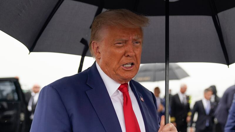 Former President Donald Trump speaks before he boards his plane at Ronald Reagan Washington...