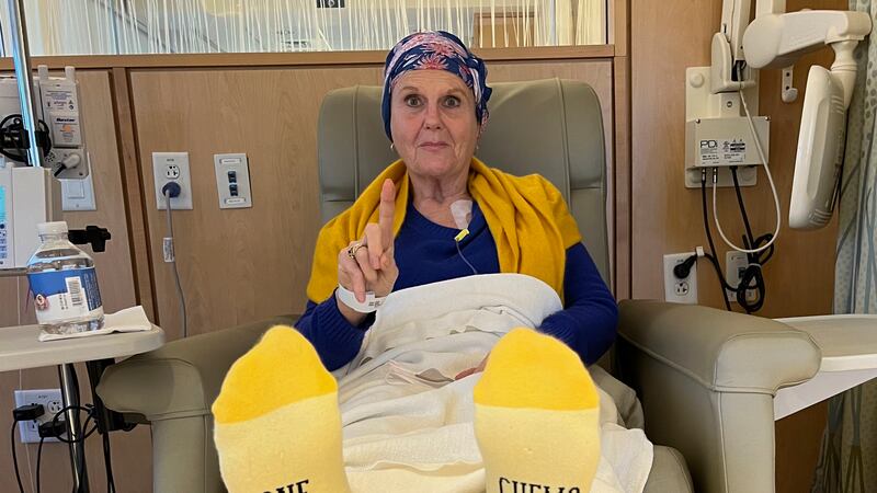 Lynda Shannon Bluestein wears socks with "One More Chemo Down" on the soles prior to a cancer...